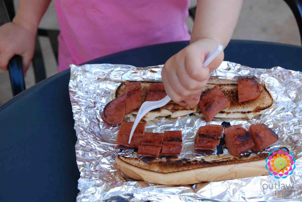 girl cutting up hot dog