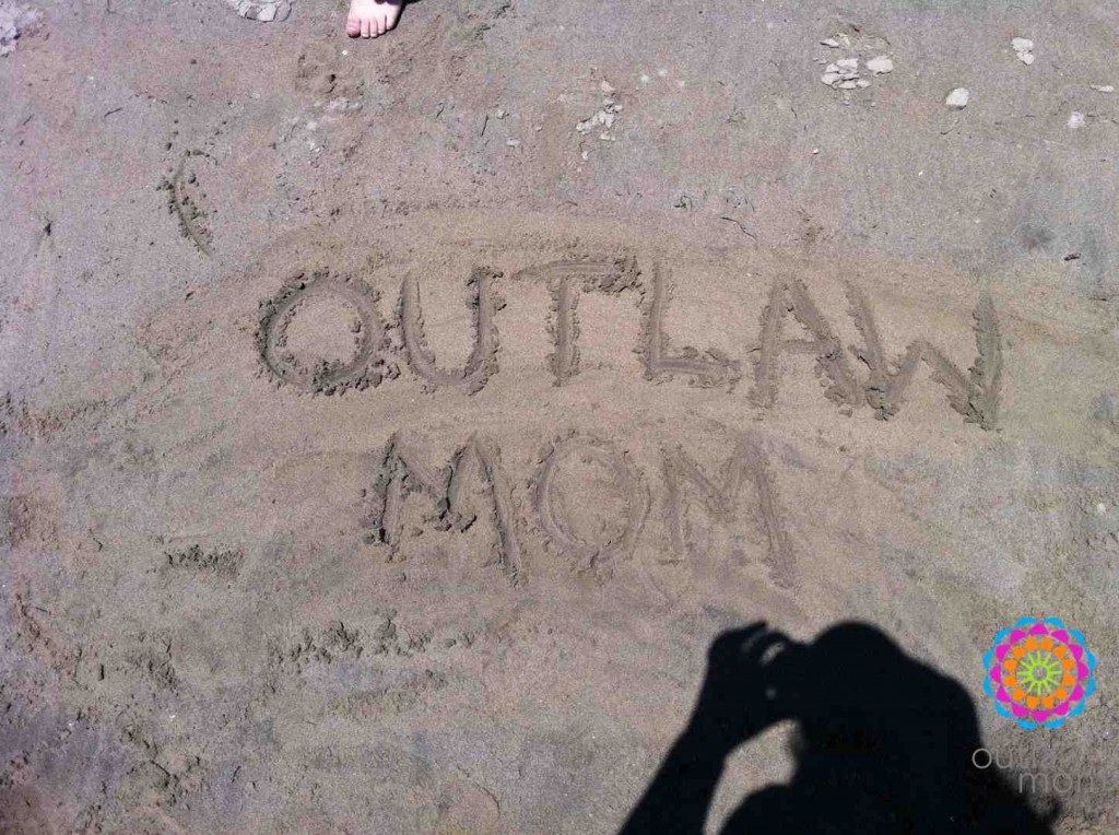 Outlaw Mom carved into the sand